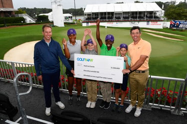 Rory McIlroy presenting a million dollar check to Youth on Course CEO Adam Heieck 