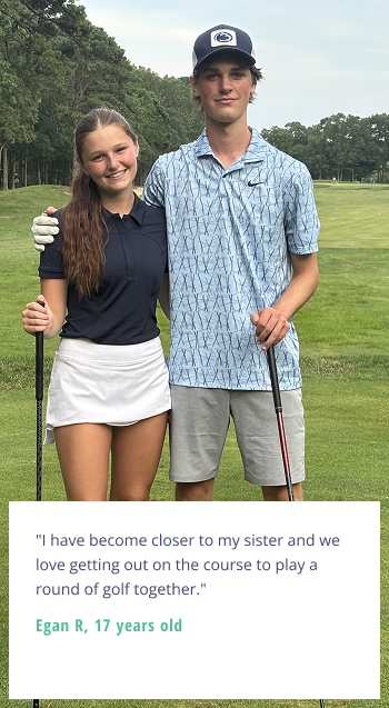 Two youth golfers, a brother and sister, smile on a golf course with clubs in hand and their arms around each other